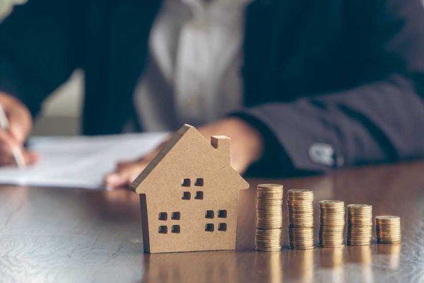 Modeling wooden houses and coins and dollars placed on wooden tables,preparation concept for house model purchase and the fastest growing real estate economy,moving home or renting property via agent